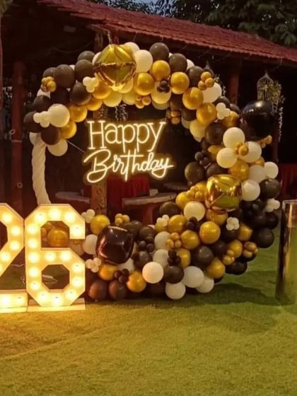 An outdoor 26th birthday party with a black, white, and gold theme.