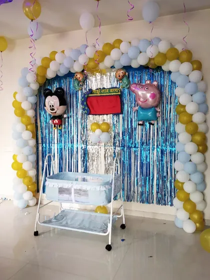 A naming ceremony decoration featuring a balloon arch and popular cartoon characters like Mickey Mouse and Peppa Pig to welcome the new baby.