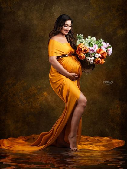 A warm and radiant portrait featuring a mustard-colored gown. The client holds a matching bouquet, and the water reflection effect adds a touch of artistry to this beautiful shot.