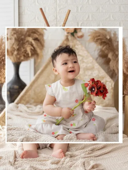A happy baby enjoys a boho-themed milestone session in our studio, complete with a lace teepee and pampas grass.