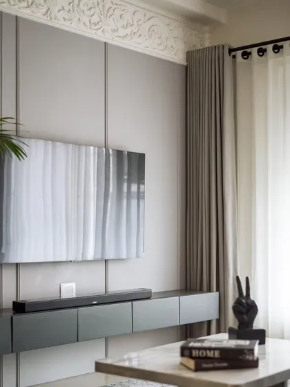 Another angle of the TV wall, showing the clean lines of the floating console and the beautiful texture of the ornamental moulding.
