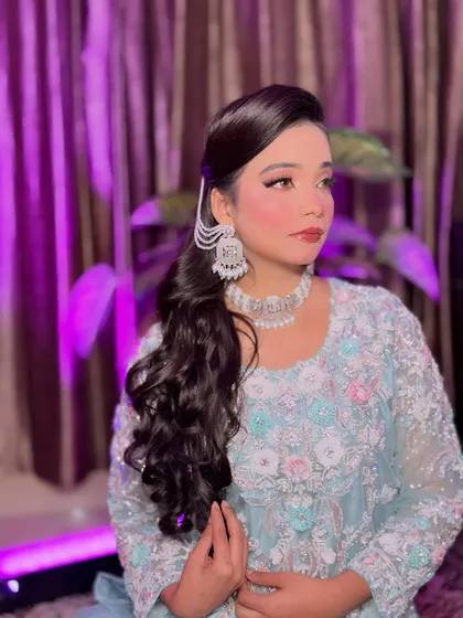 A beautiful portrait of Aira in her soft Pakistani glam look. The makeup features a pink monochromatic theme with matching eyeshadow and blush, complemented by a side-parted ponytail and statement silver earrings.