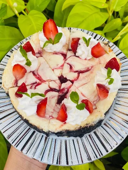 Presenting the classic Strawberry Cheesecake. A creamy, tangy cheesecake with a beautiful strawberry swirl on a crunchy cookie base, topped with fresh berries.