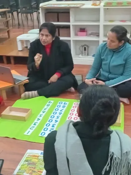 Another view of our hands-on math training. Trainees sit on the floor, working with materials on a mat, just as it is done in a real Montessori classroom. This immersive experience is crucial for understanding the flow and order of the environment.