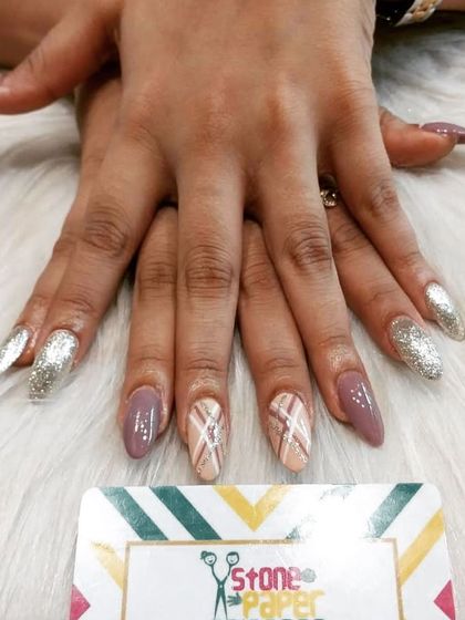 A chic and cozy design with a mix of mauve, nude, and silver glitter nails. The hand-painted plaid pattern on the accent nail ties all the colors together perfectly.