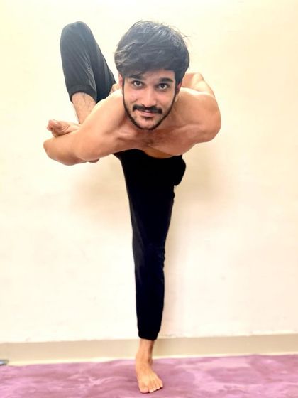 Another variation of a standing balancing pose with a bind, showcasing stability and flexibility.