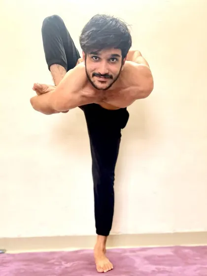 Another variation of a standing balancing pose with a bind, showcasing stability and flexibility.