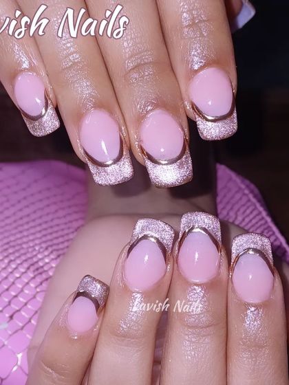 A square-tipped French manicure with a twist, featuring shimmery cat-eye tips outlined in gold.