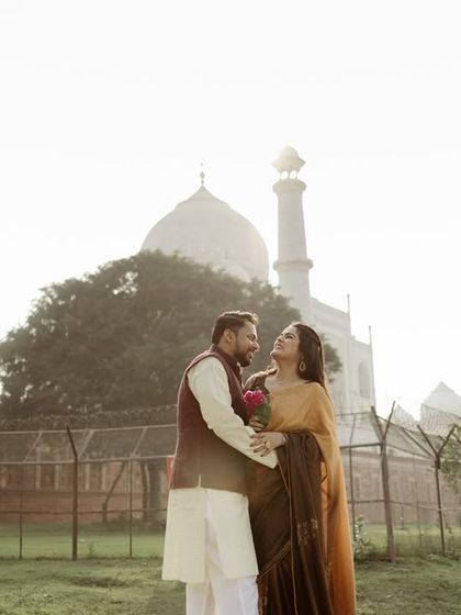 A soft, hazy morning shot with the couple sharing a laugh. Capturing the early morning light at the Taj Mahal gives the photos a dreamy, ethereal quality.