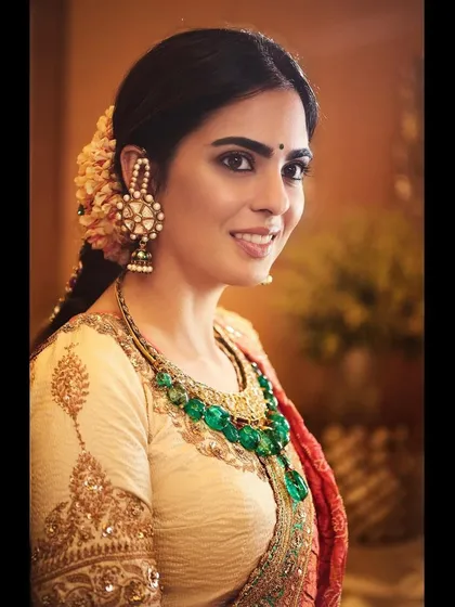 A portrait of Isha in the Anuradha Vakil ensemble, highlighting the stunning emerald necklace and traditional jhumkas. The jewelry selection was crucial to complement the rich colors of the outfit.