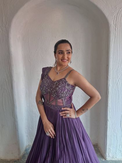 A confident pose in this stunning purple gown. The embellished bodice and flowing skirt create a beautiful silhouette.