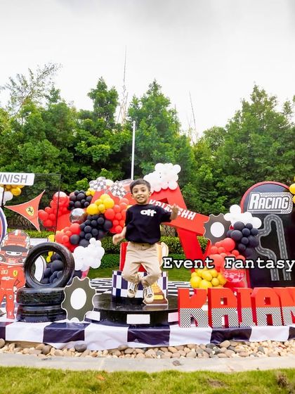 The birthday boy, Krianshh, having a blast and jumping for joy on his Ferrari-themed party stage.