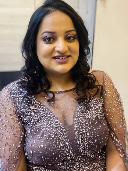 A smiling portrait of the client, ready for her evening event. The glam makeup makes her look and feel confident.