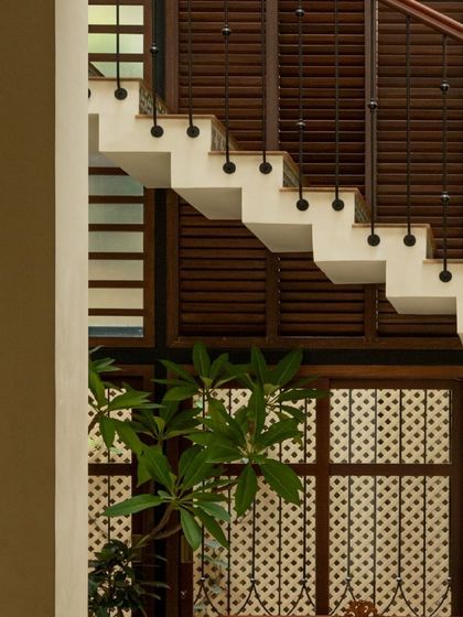 A view of the staircase at Casa 503, with its floating steps and slatted wooden screens. This design allows light and air to move freely through the home, enhancing the sense of space and openness.