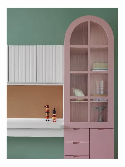Function meets creativity in this child's bedroom. The candy-floss pink cabinet with fluted glass provides beautiful storage, while the white upper cabinets have a writable surface, ensuring the child's creativity isn't limited to paper. The design is both practical and inspiring.