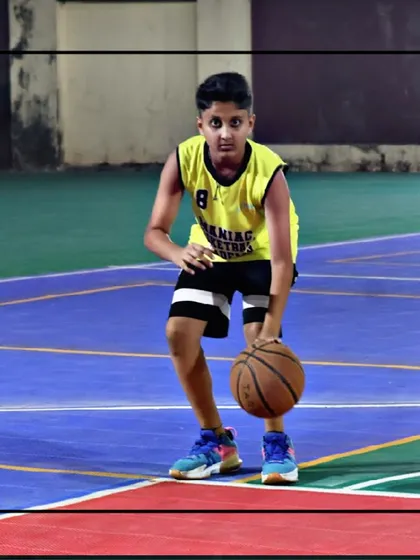 A close-up of a young player executing a low dribble. This fundamental skill is crucial for ball control and confidence on the court.