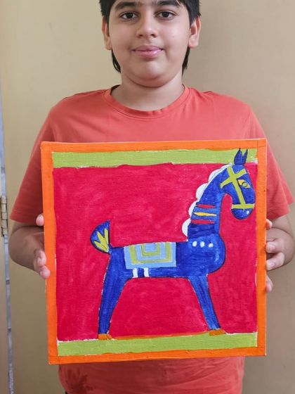 A student with his beautiful recreation of a Jamini Roy folk art painting, showcasing the bold lines and colors characteristic of the master's style.