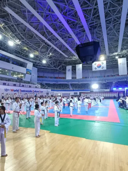 A wide view of the massive training floor at the World Taekwondo Culture Expo, with hundreds of practitioners from around the globe training in unison.