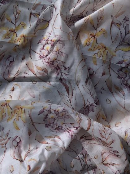 A close-up of our printed muslin fabric, showing the delicate, watercolor-like floral print on a sheer, breathable base.