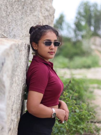 A repeat of a cool and casual outdoor portrait with sunglasses, showing a relaxed, summery vibe against a rock wall.