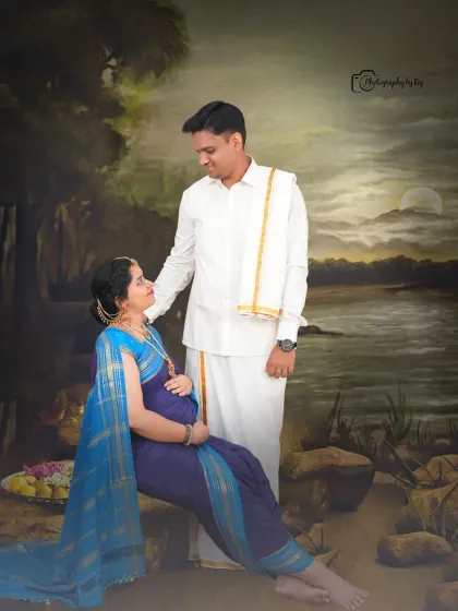 A classic Raja Ravi Varma-inspired studio portrait of a couple, with the mother-to-be seated gracefully.