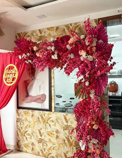 A vibrant and auspicious setup for a Jain Tapasvi ceremony. We created this stunning floral arch using bold pink artificial blossoms and golden palm leaves to frame the sacred space with color and reverence.