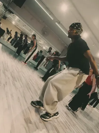 An instructor leads a workshop, showcasing his unique style and flow to a room full of attentive dancers.