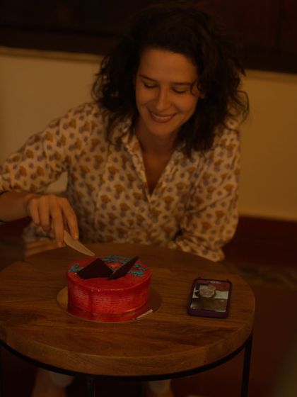 A guest happily cuts her birthday cake, surrounded by the warm and festive atmosphere created by her friends and our team.