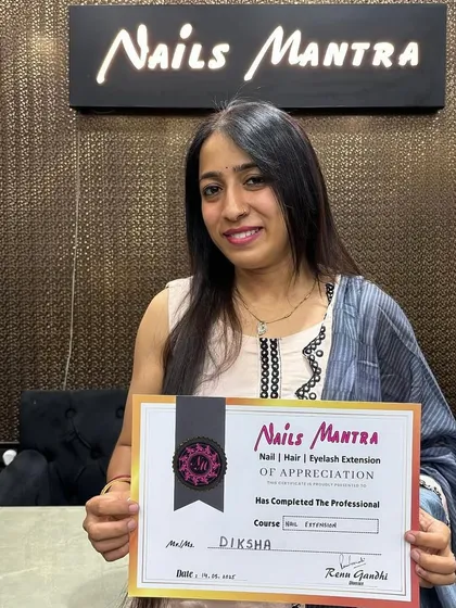 A proud graduate, Diksha, poses with her professional certification. We offer a range of courses from nail extensions to permanent makeup to help you build your career.