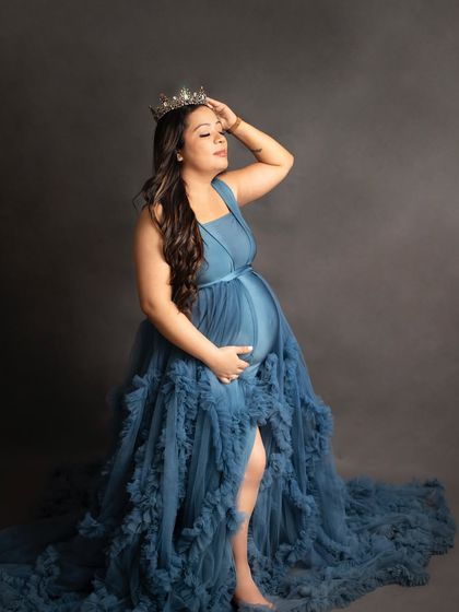 A powerful solo portrait of a mother-to-be wearing a crown with her blue gown. This shot is all about celebrating the queen that you are.
