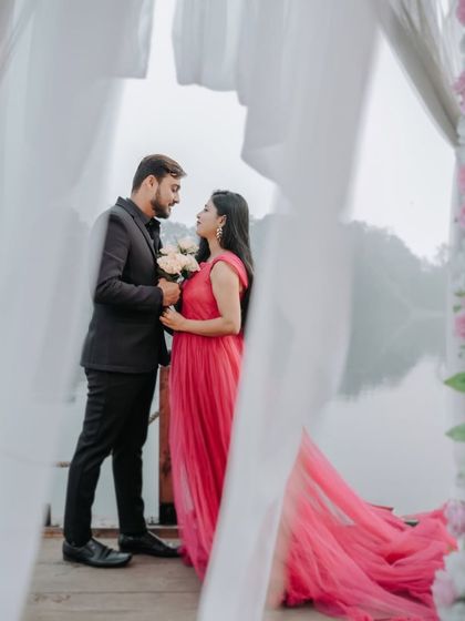 A romantic and misty lakeside maternity shoot. The vibrant pink gown with its long train looks incredible against the soft, foggy backdrop.