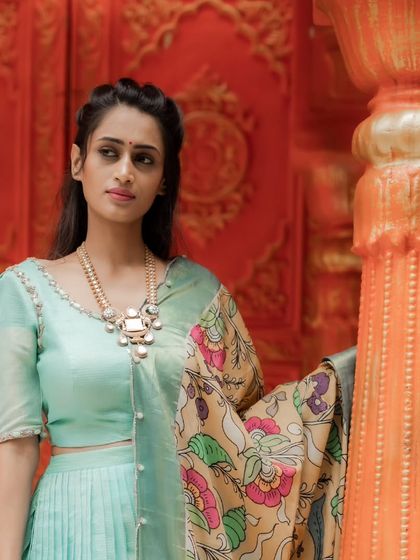 A sea blue chanderi silk pleated lehenga paired with a contrasting hand-painted Kalamkari mustard dupatta. A timeless piece that celebrates Indian artistry.