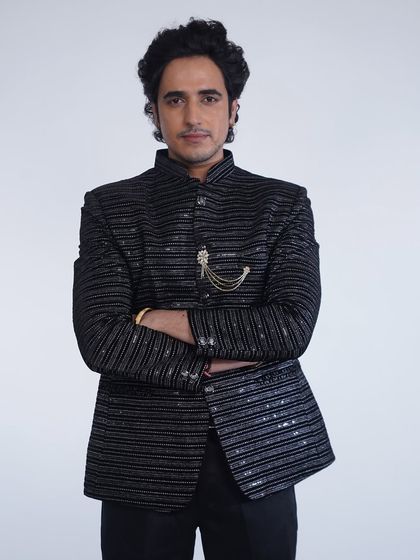 A confident pose in our black striped bandhgala jacket. The brooch adds a touch of regal flair to this modern ethnic look.