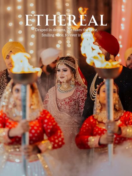 A cinematic shot of the bride, Gurbani, making her entrance, flanked by performers holding torches, creating a dramatic and ethereal 'queen's entry' moment.