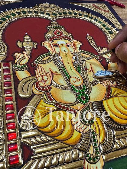 This image shows the final outlining on a beautiful Ganesha painting. The fine black lines are one of the last steps and make the gold work truly stand out.