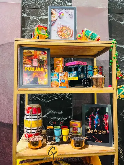 A vibrant Punjabi-themed decor shelf, complete with a miniature truck, dhol, and colourful lassi glasses to set the mood.