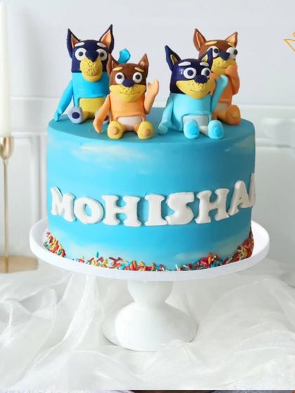 A fun Bluey-themed cake for a fan of the beloved show. This design features the Heeler family, ready for a playful adventure on a bright blue cake.