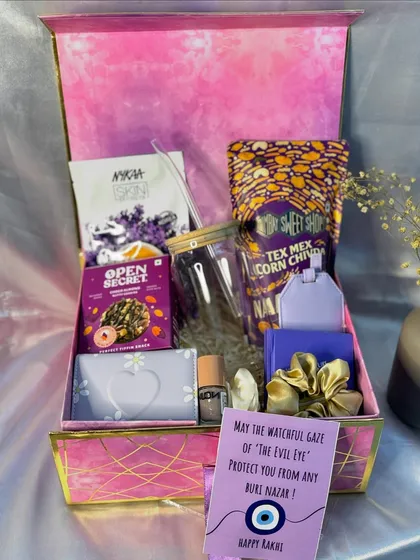 This "Evil Eye" themed hamper is perfect for your sister this Rakhi. It’s packed with skincare goodies, snacks, a personalized sipper, and a special card to protect her from all 'buri nazar'.
