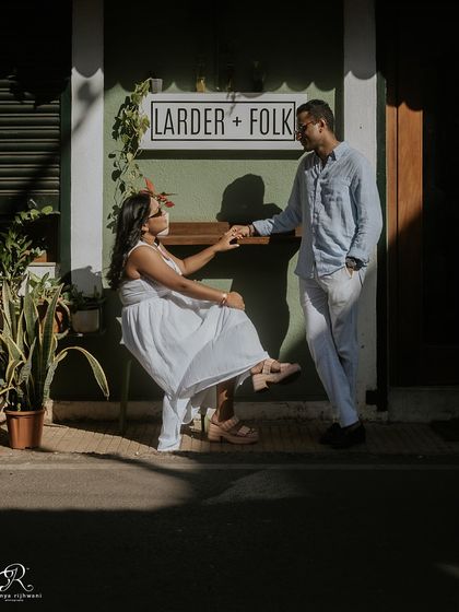 A candid moment of connection in the Latin Quarters of Panjim. The strong shadows and bright sunlight create a dramatic effect, highlighting the couple as they share a quiet moment.