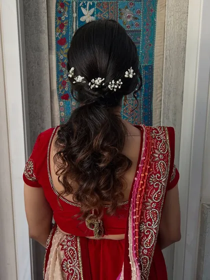 A classic ponytail with soft curls and delicate baby's breath accessories. This look is timeless, romantic, and effortlessly elegant.