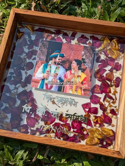 This 12x12 inch teak wood frame showcases preserved red rose petals and a wedding photo. The depth of the frame adds a beautiful shadow box effect.