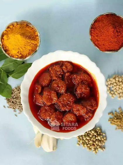 My fresh prawns pickle, surrounded by some of the key ingredients I use: turmeric, chilli powder, garlic, and curry leaves. Only natural ingredients go into my pickles.