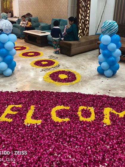 A large "WELCOME" message created with flower petals on the floor, making for a grand and beautiful gesture for a newborn's arrival.