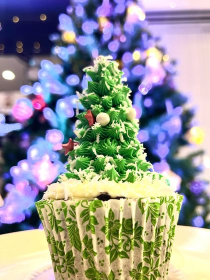 A Christmas tree you can eat. This festive cupcake is topped with a swirl of green frosting decorated to look like a Christmas tree, complete with sprinkles for ornaments.