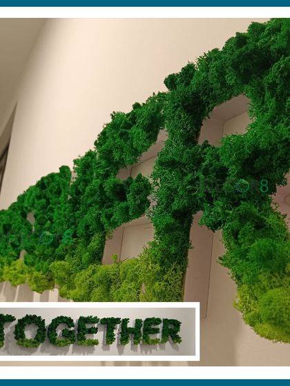 We can create custom lettering and logos using preserved moss. This "TOGETHER" sign is a perfect example of how to bring a positive and green message into a collaborative workspace, adding both texture and meaning to the wall.