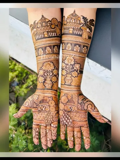 A stunning bridal design featuring pichwai-inspired elements like lotus vases and peacocks, combined with traditional architecture. The result is a unique and artistic look.