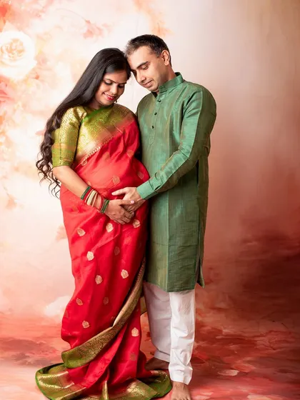 This couple chose traditional attire for their studio maternity session. The rich colors of the saree and kurta create a warm and timeless portrait celebrating their journey together.