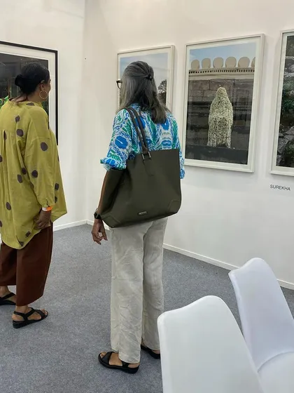 Two visitors in conversation in front of Surekha's photographs.