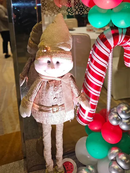 A cute Christmas elf and candy cane balloon prop. These small, themed details add to the festive charm of a holiday party.