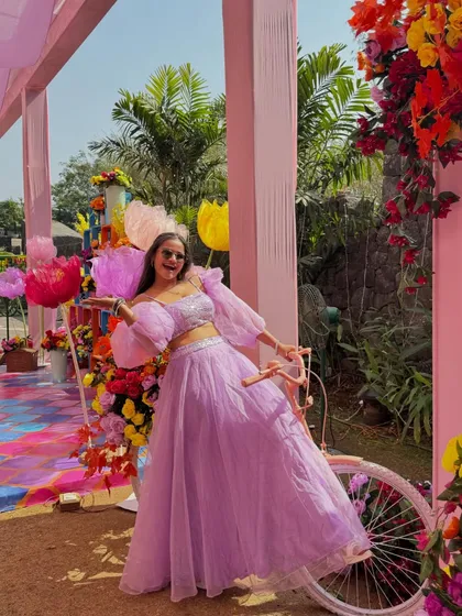 Having some fun with the props at a vibrant Haldi ceremony. The colorful decor, including this decorated bicycle, made for great photo opportunities.